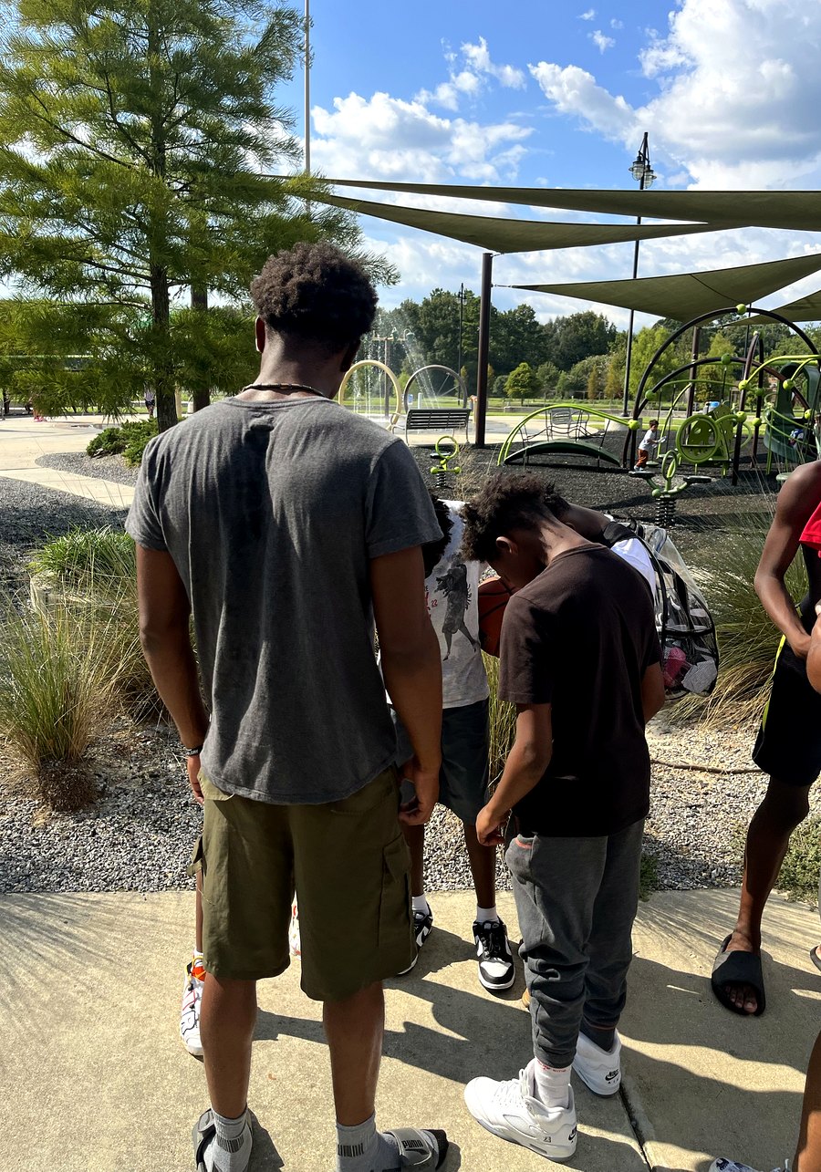 Kids playing at a splash pad during a RaqGiveback community outing.