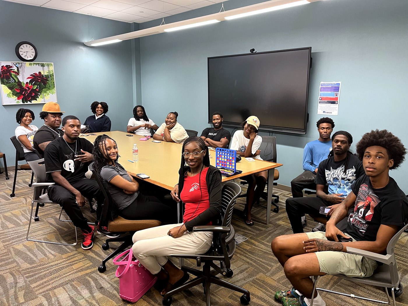 RaqGiveback mentors and ambassadors meeting together at a community center.